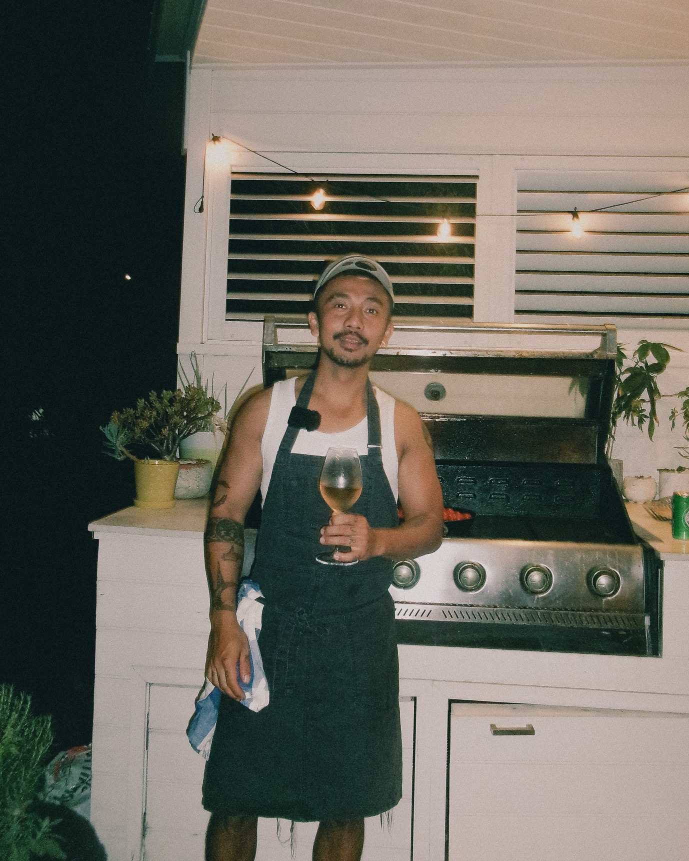 The Boy at the grill, glass in hand